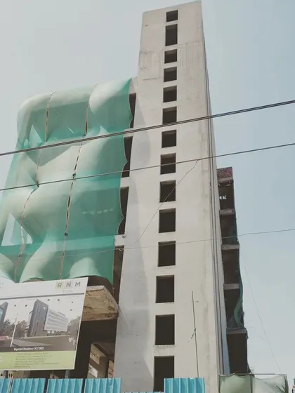 An upcoming commercial project on Mathura Road under construction. This image captures the scale of the building, with its tall service core and the main structure taking shape.