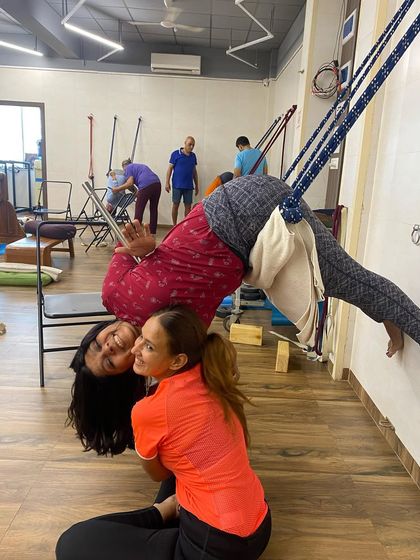A supported twisting inversion using the wall ropes. This pose is both challenging and rejuvenating, and the props make it a joyful experience.