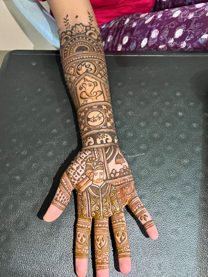A full view of the arm, showing how the groom portrait is balanced with traditional motifs like Ganesha and elephants.