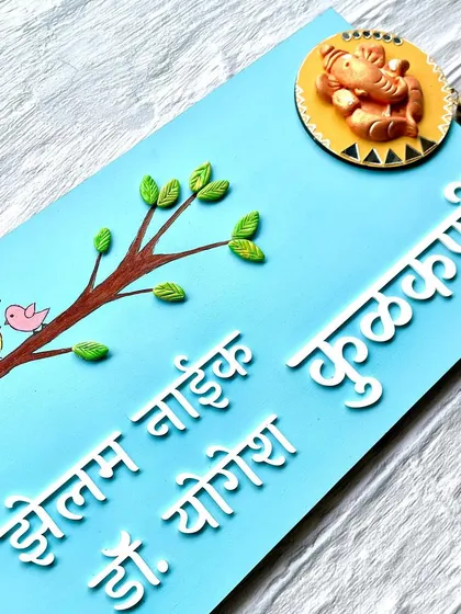 This custom nameplate combines a hand-painted nature theme with a beautiful terracotta Ganesha and a small bell for a truly unique design.