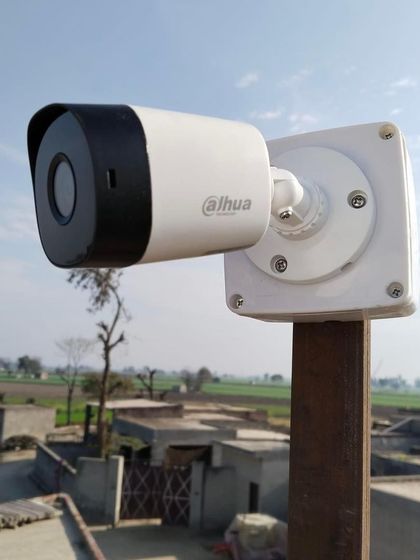 This Dahua camera is mounted on a pole, providing a great vantage point for monitoring a large open area like a farm or backyard.