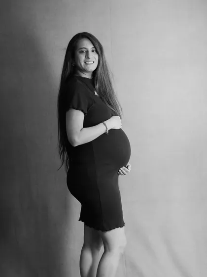 A classic black and white profile portrait. This timeless shot beautifully captures the silhouette of the baby bump and the happy glow of the mom-to-be.