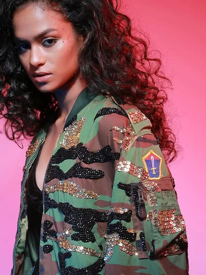 A close-up on a sequined camouflage jacket for the brand Diseno.in. We use focused lighting to highlight texture and embellishments, ensuring every detail of the garment is visible and appealing for e-commerce.