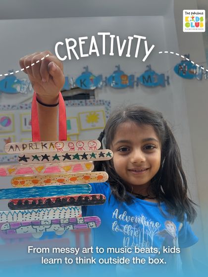 From messy art to music beats, I help kids learn to think outside the box. This young girl proudly holds up her decorated popsicle sticks, a simple activity that encourages creativity and personal expression.