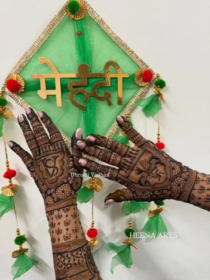 A festive design featuring the couple's initials. This is a great way for bridesmaids and family members to have personalized mehendi too.