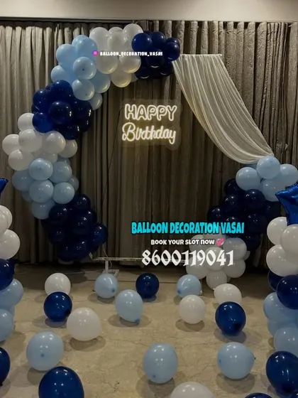 A birthday backdrop with a blue and white color theme. This setup includes a balloon half-arch and matching balloon pillars topped with star foil balloons.