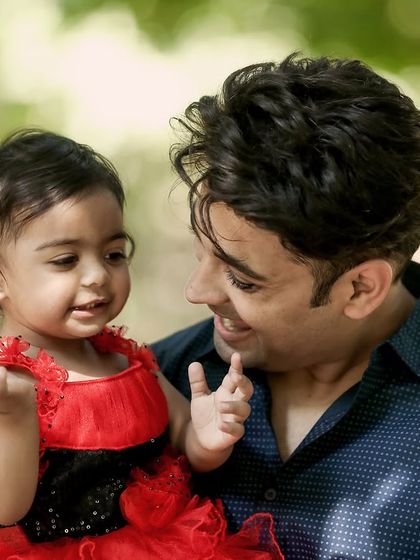 A father and daughter share a sweet, interactive moment during their outdoor session.