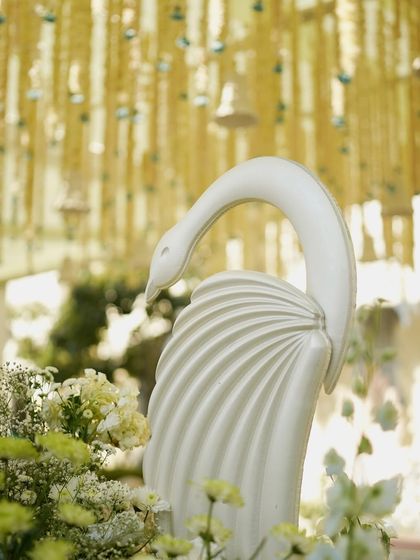 A graceful swan statue, adding a touch of elegance to the feather-themed wedding decor.