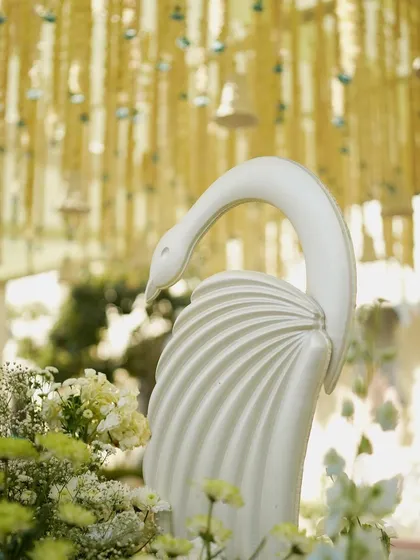 A graceful swan statue, adding a touch of elegance to the feather-themed wedding decor.