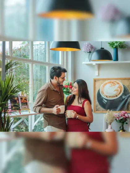 A candid moment over coffee. The natural interaction and warm lighting in the cafe create a genuine and relatable pre-wedding portrait.
