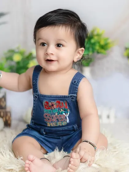 A quick outfit change into denim overalls for a more casual and playful look during the same six-month session.