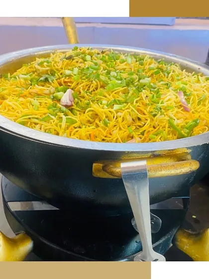 A large wok filled with freshly tossed noodles, a staple of our live Pan-Asian food stations.
