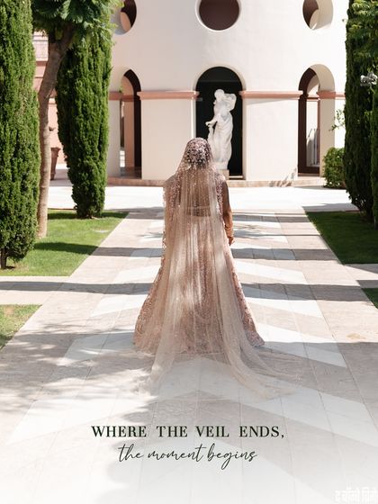 Where the veil ends, the moment begins. This stunning shot captures the drama and romance of the bride's long, flowing veil as she walks towards her forever.