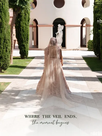 Where the veil ends, the moment begins. This stunning shot captures the drama and romance of the bride's long, flowing veil as she walks towards her forever.