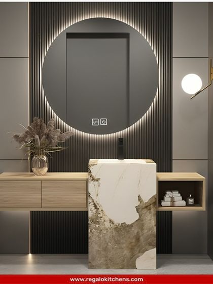 A unique, artistic vanity design featuring a freestanding marble pedestal sink. The floating wood drawers and large, backlit mirror complete this stunning composition.
