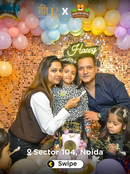 A beautiful family portrait during a birthday celebration. The parents and birthday girl pose for a photo in front of the sparkling sequin backdrop.