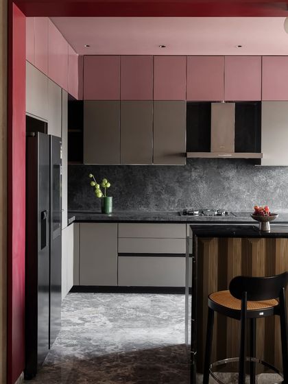 The kitchen in the Scarlet Horizon project balances bold color with sophisticated materials. We paired dusty pink upper cabinets with grey lower units and a rugged charcoal slate counter. The result is a functional space that feels both vibrant and elegantly grounded.