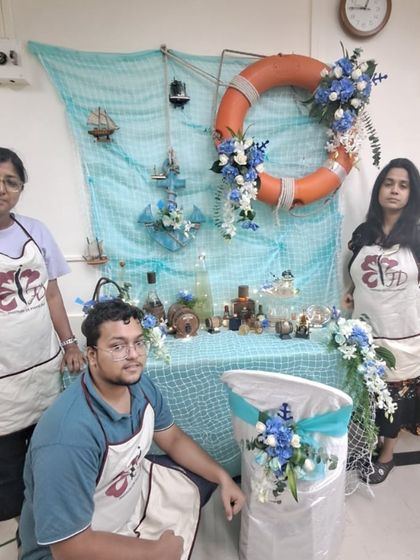 Students learn to create immersive, themed environments. This nautical-themed display uses a blue and white color palette, netting, and props like anchors to transport the viewer to the seaside.