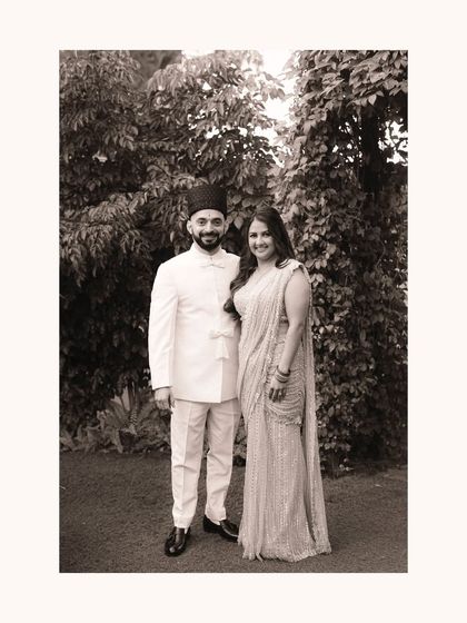 A classic black and white portrait that feels like a family heirloom. The formal pose is softened by their gentle smiles, capturing a moment of quiet pride and happiness on their wedding day.
