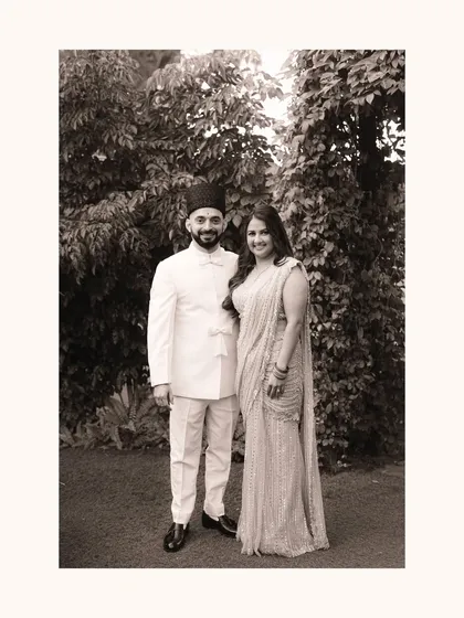 A classic black and white portrait that feels like a family heirloom. The formal pose is softened by their gentle smiles, capturing a moment of quiet pride and happiness on their wedding day.