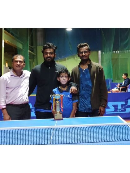 A moment of shared victory. Our player Vishal Vaibhav with his trophy, supported by his coaches and fellow players at the tournament venue.