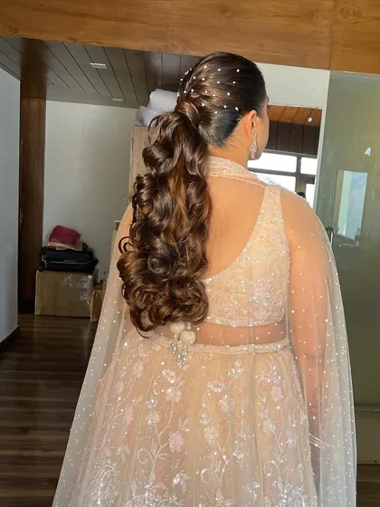 The back view of the messy ponytail, showing the scattered pearls that add a touch of magic to the voluminous curls.