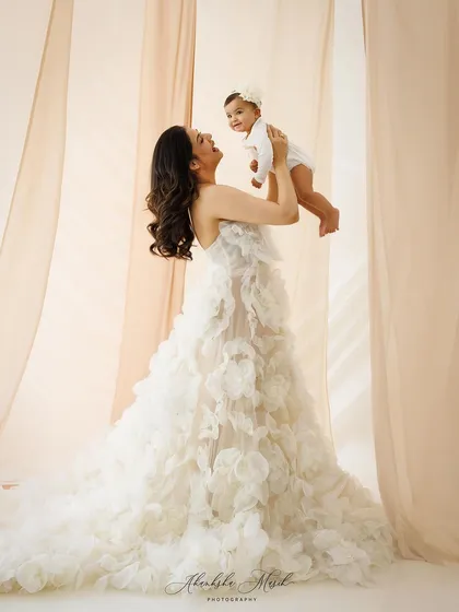 This portrait embodies the elegance and grace of motherhood. The flowing gown and soft lighting create a truly radiant and aspirational image, celebrating the powerful connection between a mother and her child.