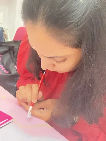 A student practices her fine line work, an essential skill for creating intricate and professional-looking nail art.