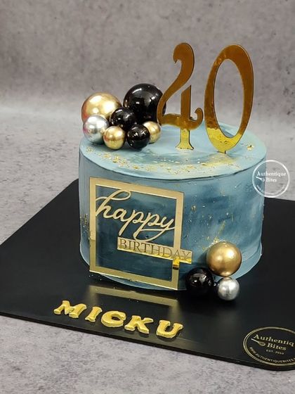 A sleek and modern "Classy @ 40" cake. The deep blue marble design with black, gold, and silver spheres is perfect for a stylish 40th birthday.