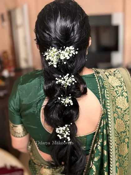 A simple and elegant mermaid braid created without any hair extensions. The style is adorned with sprigs of baby's breath for a delicate and romantic finish.