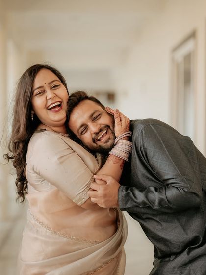 A moment of pure, uninhibited laughter. This candid photo captures the playful and affectionate bond between the couple, resulting in a portrait that is full of life and personality.