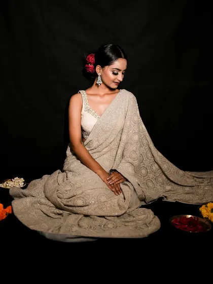 A peaceful portrait capturing the spirit of Diwali. The model is surrounded by traditional elements like flowers and diyas, adding to the festive mood.