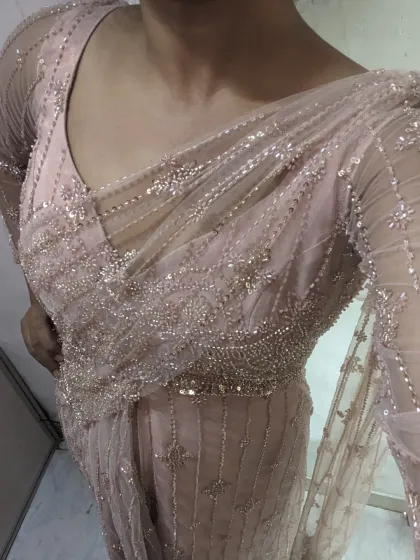 Get the look of a saree with the comfort of a gown. This pastel pink beaded outfit gives a saree vibe without any of the draping hassle.