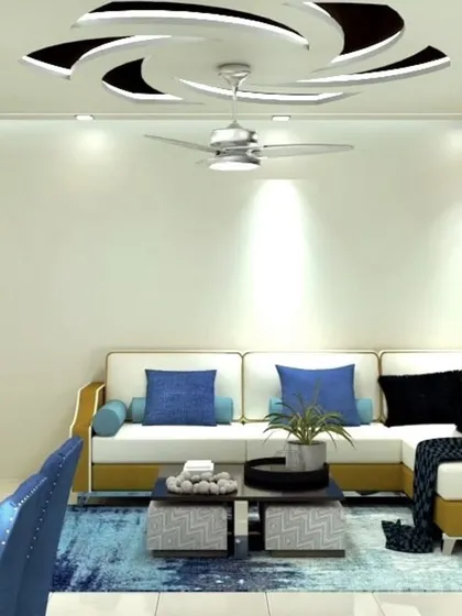 The L-shaped sofa in mustard and white is the centerpiece of this living room. Above, a dynamic spiral false ceiling design adds a unique architectural element to the space.