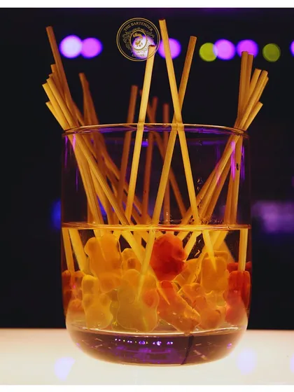 A glass filled with gummy bear candy sticks, ready to be used as a fun and edible garnish for our cocktails and mocktails.