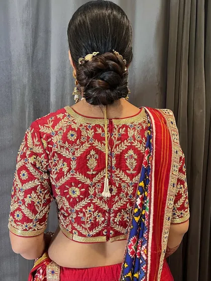 A close-up of the intricate braiding within the classic bun. The small gold accessory adds just the right amount of detail.