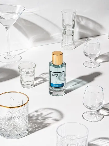 A conceptual shot for a perfume, using an array of empty glasses and strong shadows. This art direction plays with light and form to create a unique, abstract visual that sparks curiosity.