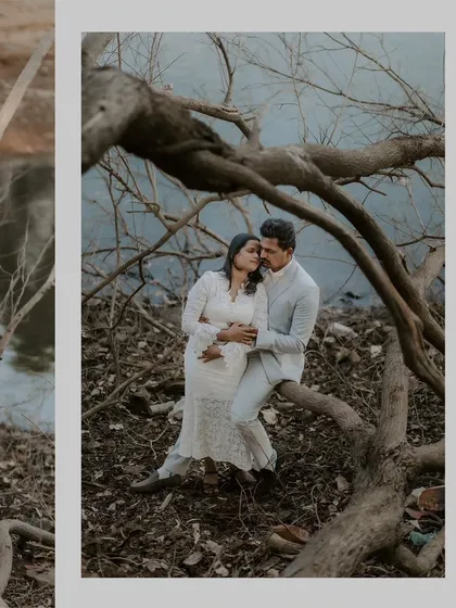 A couple sharing an intimate moment while sitting on a gnarled tree branch, perfectly framed by the natural surroundings.