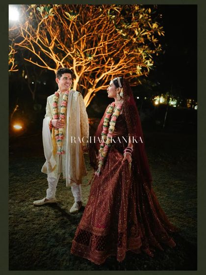 A romantic portrait of the couple under a tree lit with fairy lights, their gazes locked in a moment of nighttime magic.