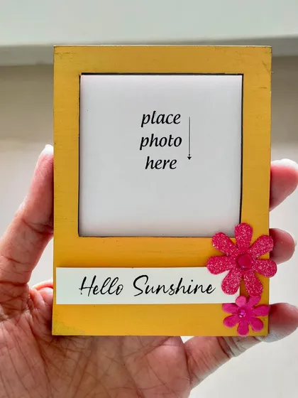 This mini magnetic photo frame in a sunny yellow says 'Hello Sunshine'. It's a small but cheerful way to display a precious memory.