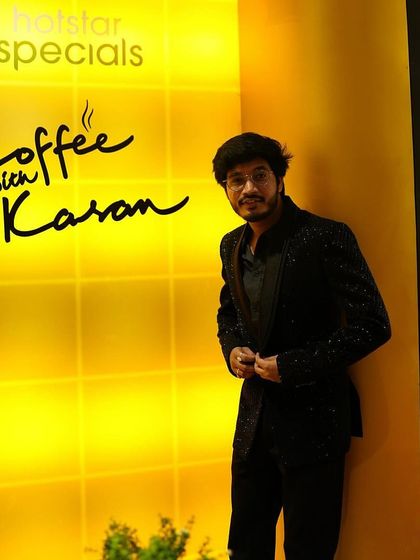Another shot of RJ Raghav in his custom Dawood Khan jacket. The fit and fabric were chosen to create a sharp silhouette against the bright, iconic background of the show's set.