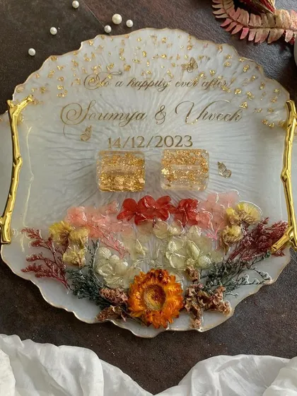 A beautiful engagement ring platter with preserved flowers, gold handles, and personalized text. A perfect centerpiece for your ring ceremony.