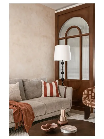 A similar shot of the living room seating, emphasizing the warm and inviting color palette. The design proves that you can mix patterns and textures effectively when you stick to a cohesive color story.