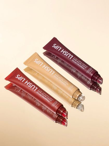 Reflections and repetition create a sleek, modern look. This shot uses a mirror to multiply the lip gloss tubes, resulting in a clean, graphic composition that highlights the product's packaging.