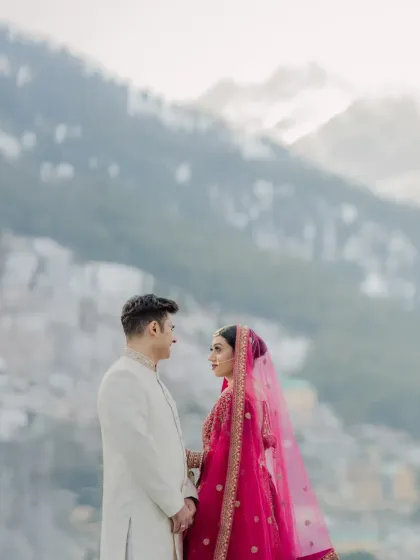 A romantic portrait of the couple looking at each other, with the soft, misty mountains creating a dreamy backdrop.