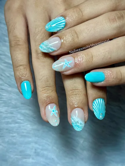 The combination of solid turquoise nails and detailed accent nails creates a balanced and fun look.