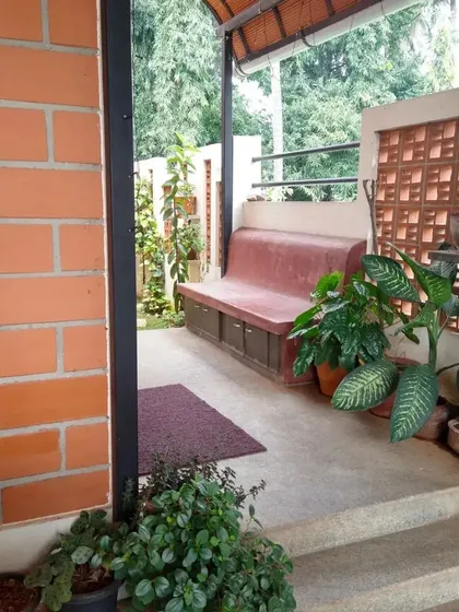 Another view of a plant-filled verandah, with a built-in bench, demonstrating the fusion of architecture and nature.