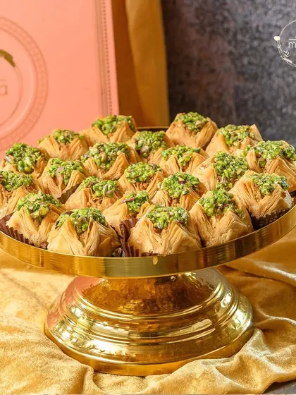 I believe in the beauty of gourmet treats. This platter showcases my handcrafted baklava, made with flaky pastry and premium pistachios, presented on a golden stand to add a touch of luxury to any festive table.