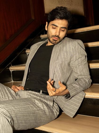 A more relaxed, seated portrait from the GQ shoot. The lighting is moodier here, creating a pensive and introspective feel.