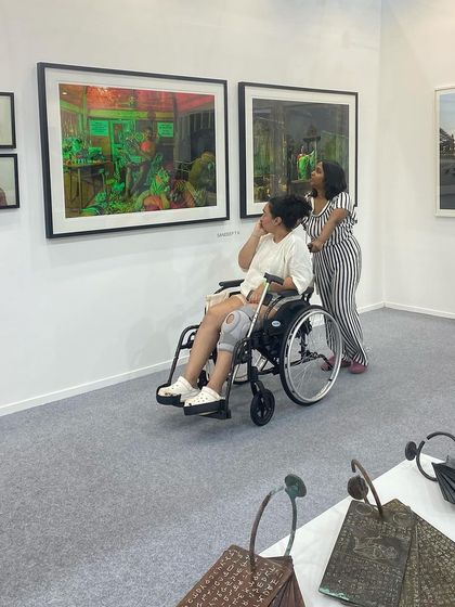 A visitor in a wheelchair admiring the art, showing our events are accessible and inclusive.